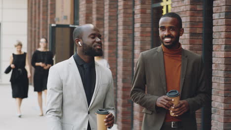 Two-African-American-Businessmen-Chatting-over-Coffee-on-Walk